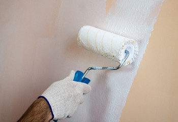 Close up view of man's hand holding paint roller,