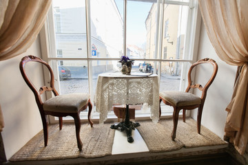 Table and chairs by window in empty cafe