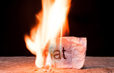 Word Fat on crumpled piece of paper burn. Concept of Burn your Fat and health care life style