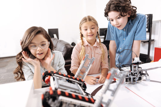 Shocked kids observing electronic robots at school