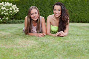 Portrait of beautiful young women with long hair lying in park