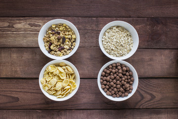 Bowls of various cereals  from top view . Wooden table