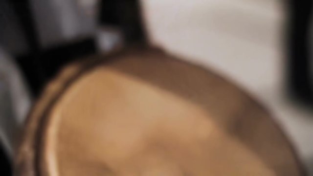 Man hits the drum with his hands close-up