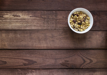 White bowl with muesli on wooden table