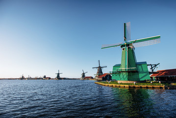 Fototapeta na wymiar Colorful spring day with traditional Dutch windmills canal in Ro