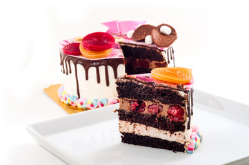 Big piece of sweet and colorful chocolate birthday cake with bright and vivid candy