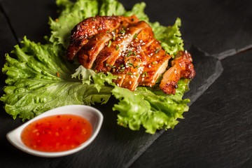 Grilled chicken breast with sesame seeds. Sweet and sour sauce. Restaurant