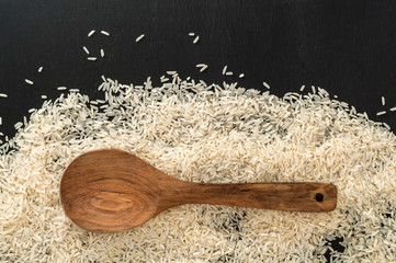 Wood spoon on top of heap of Jasmine white rice