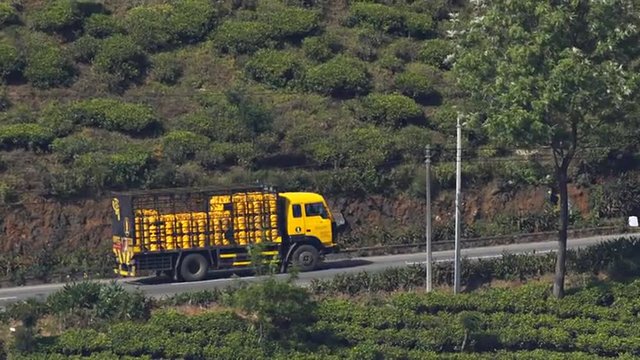 Heavy Truck Carrying Gas Canisters Labors up a Hill on a Highway in Sri lanka