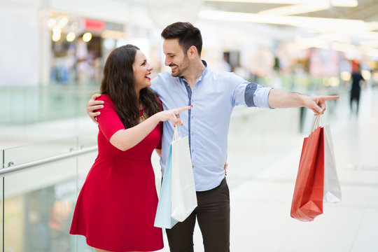Beautiful couple enjoy shopping together in mall