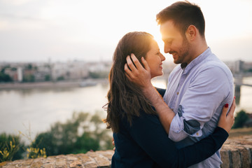 Romantic couple cuddling and kissing outdoors