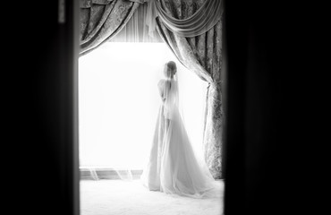 Bride near the window in a white dress