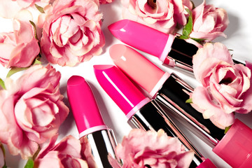 Obraz na płótnie Canvas Spring set of lipsticks in pink flowers. Beauty cosmetic collection. Fashion trends in cosmetics, bright lips