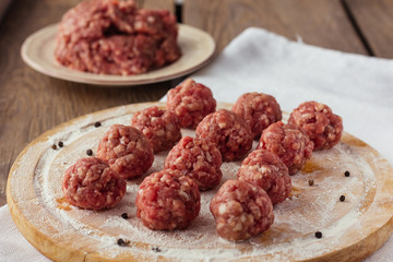Raw meatballs on cutting board