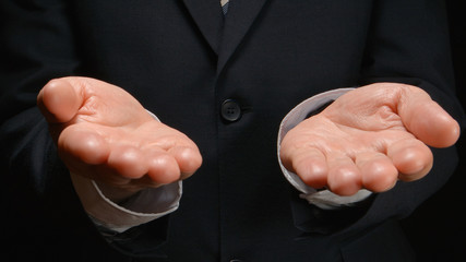 Businessman shows by hands gestures: balance, choice