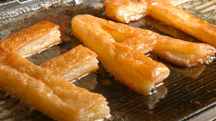 FAT letters fry in oil in a grill (close up)