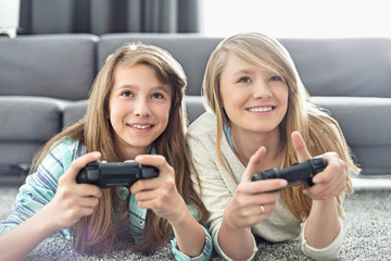 Sisters playing video games in living room