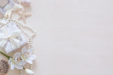 Present, beads, seashells, orchid and space for text on wooden background