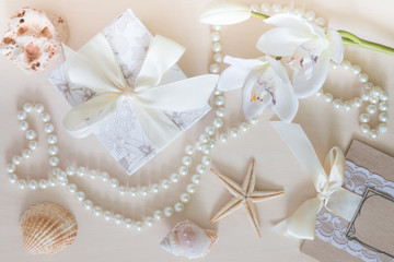 Fototapeta na wymiar Present, beads, seashells, orchid on wooden background