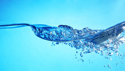 Clear blue water wawes with bubbles in the left.