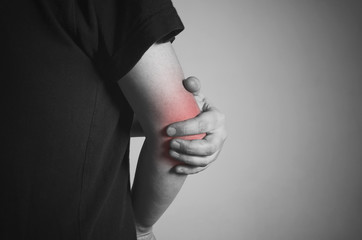 Closeup of pain in an elbow over gray background