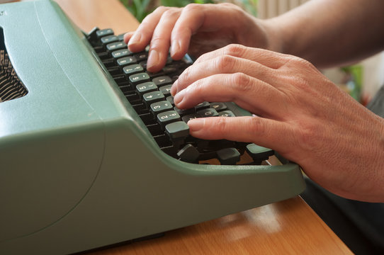 détail mains d'homme sur clavier de machine à écrire ancienne
