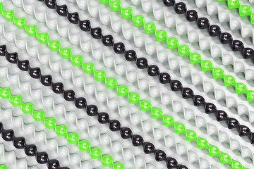 Black, white and green plastic spiral sticks on white background