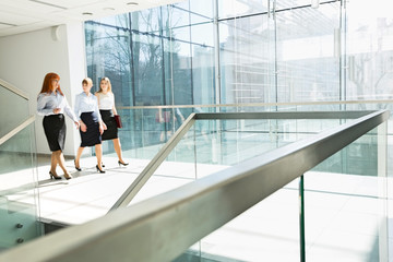 Fototapeta na wymiar Full-length of businesswomen walking at office hallway