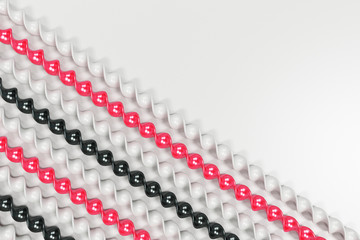 Black, white and red plastic spiral sticks on white background