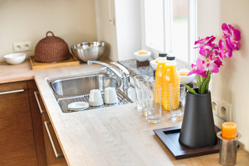 Flower vase with juice bottles on kitchen counter