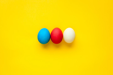 Three colorful handmade easter eggs isolated on a orange background