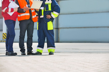 Low section of workers discussing in shipping yard