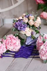 bridal bouquet from roses and a hydrangea in an environment of bouquets of flowers for bridesmaids and a bow-tie for the groom's friends