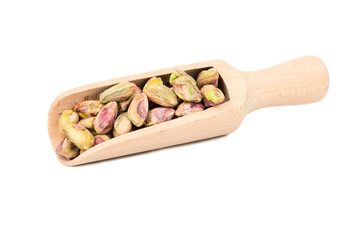 Pistachio nuts without a shell in a scoop on a white background