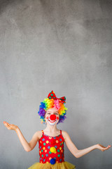 Funny kid clown playing indoor