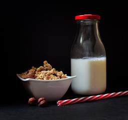 Healthy breakfast - musli and milk on dark background.