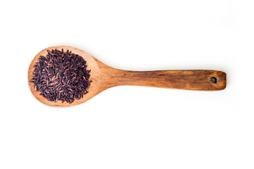 Black raw rice on wooden spoon on white background