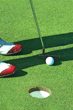 Close up of person putting golf ball on golf course