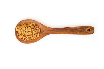 Heap of unpolished rice in wood spoon on white background