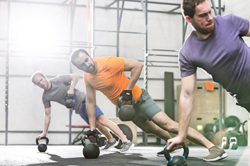 Men exercising with kettlebells in crossfit gym