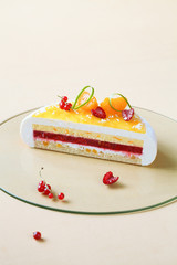 Inside of Contemporary Coconut, Raspberry and Tangerine Mousse Cake, on light yellow background.