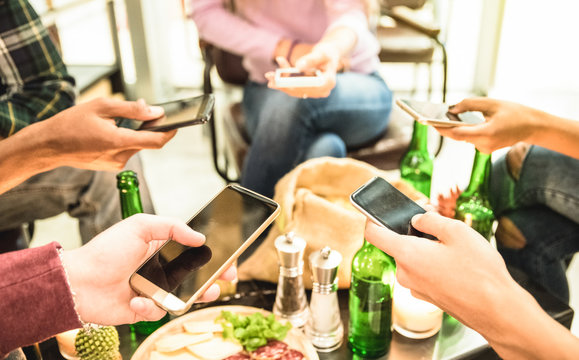 Group of multicultural friends having fun on smartphone at bar - People hands using mobile smart phone - Technology concept with addicted men and women - High iso image with shallow depth of field