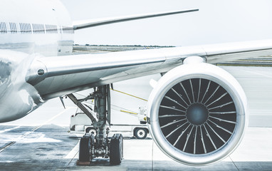 Fototapeta premium Szczegóły skrzydła silnika samolotu na bramie terminalu przed startem - Koncepcja podróży Wanderlust na całym świecie z samolotem na lotnisku międzynarodowym - Retro filtr kontrastu z jasnoniebieskimi odcieniami kolorów