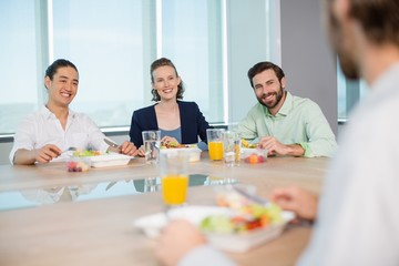 Smiling business executives having meal in office