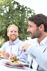 Businessmen having food at outdoor restaurant