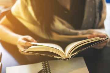 Young woman reading a book at the coffee shop