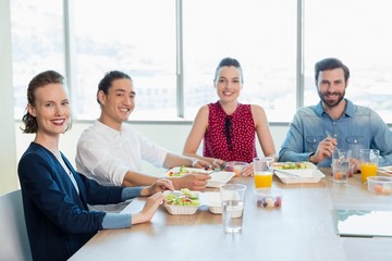 Smiling business executive having meal in office