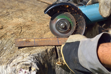 Electric grinder. A man working with electric grinder tool on steel structure, sparks flying