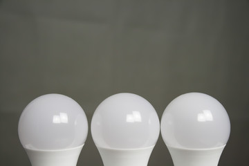 Drei weisse Glühbirnen vor grauem Hintergrund