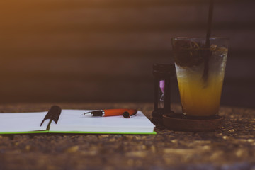 open a blank white notebook on the table. pen and fruit juice on the table.